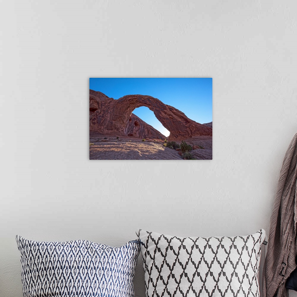 A bohemian room featuring The sun setting behind the Corona Arch in Bootlegger Canyon, Moab, Arches National Park, Utah.