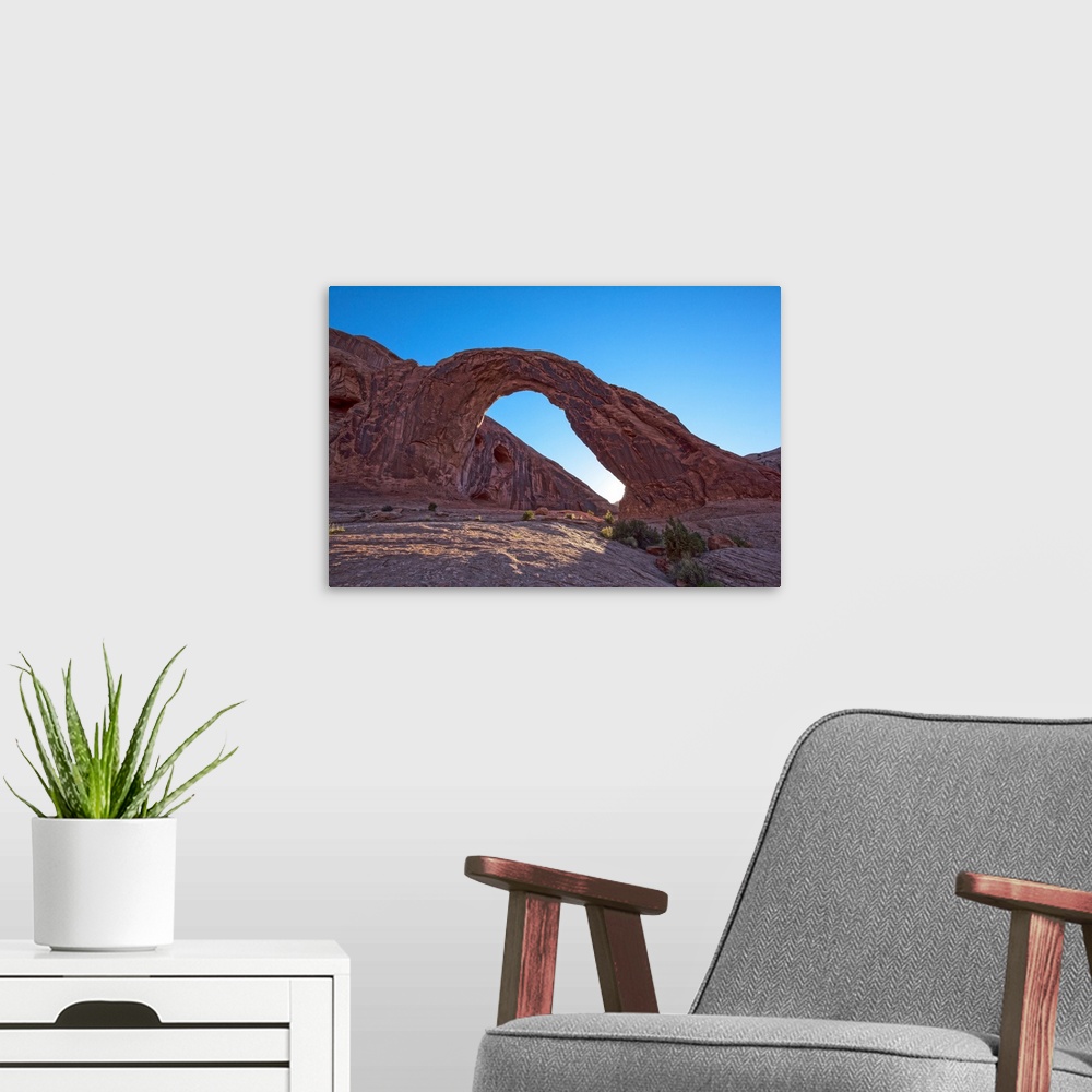 A modern room featuring The sun setting behind the Corona Arch in Bootlegger Canyon, Moab, Arches National Park, Utah.