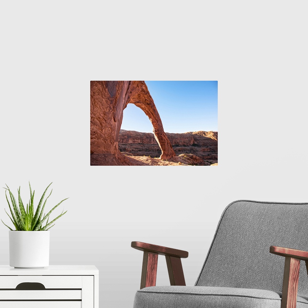 A modern room featuring Sunlight shining on the desert landscape around the Corona Arch, Arches National Park, Utah.