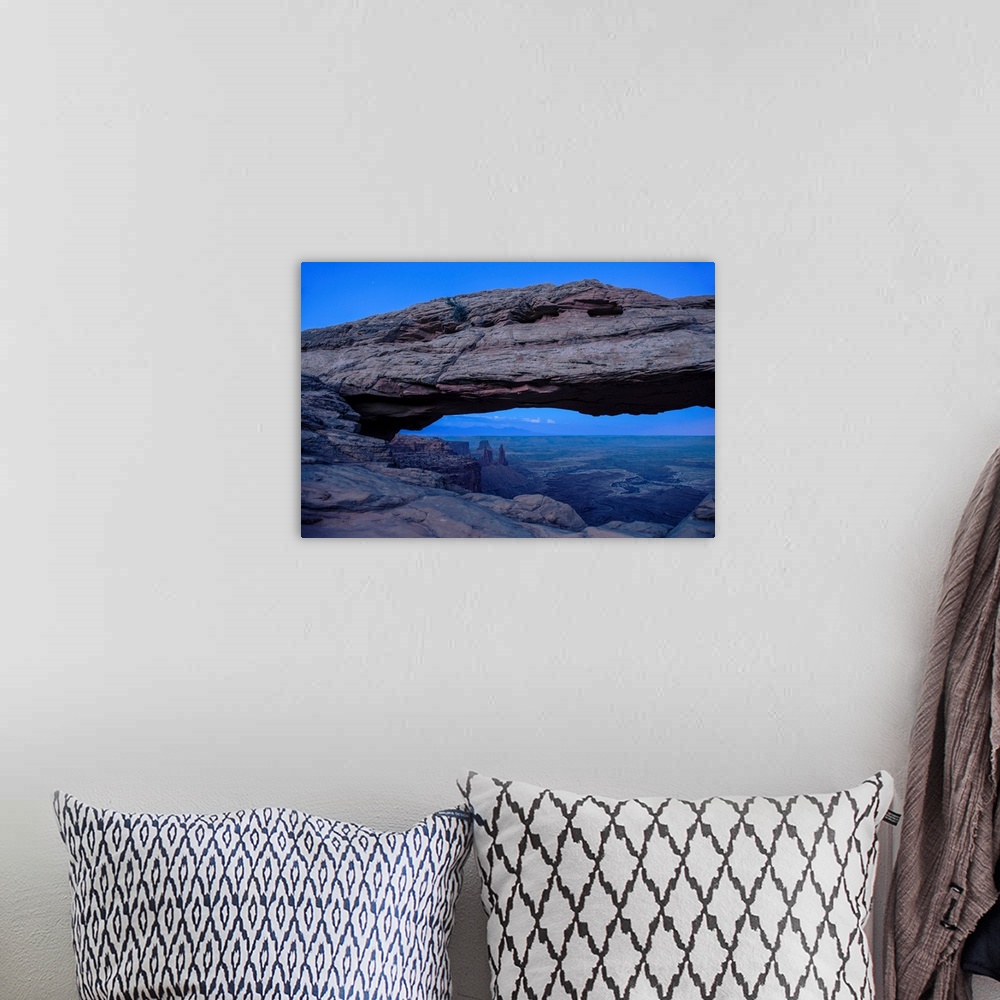 A bohemian room featuring View of rock formations in Buck Canyon, framed by the Mesa Arch in Canyonlands National Park, Moa...