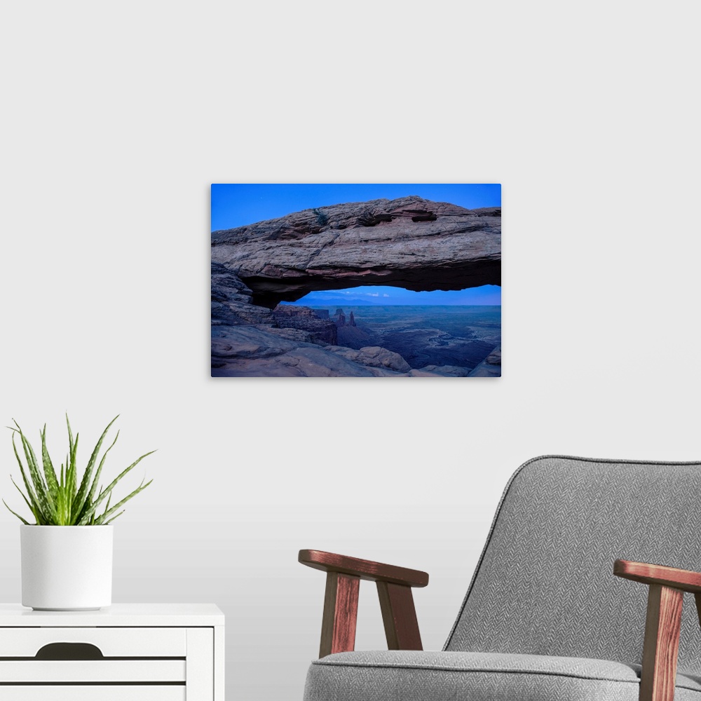 A modern room featuring View of rock formations in Buck Canyon, framed by the Mesa Arch in Canyonlands National Park, Moa...