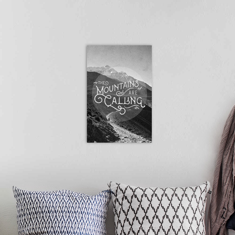 A bohemian room featuring Contemporary typography art against a black and white image of a mountainous wilderness scene.