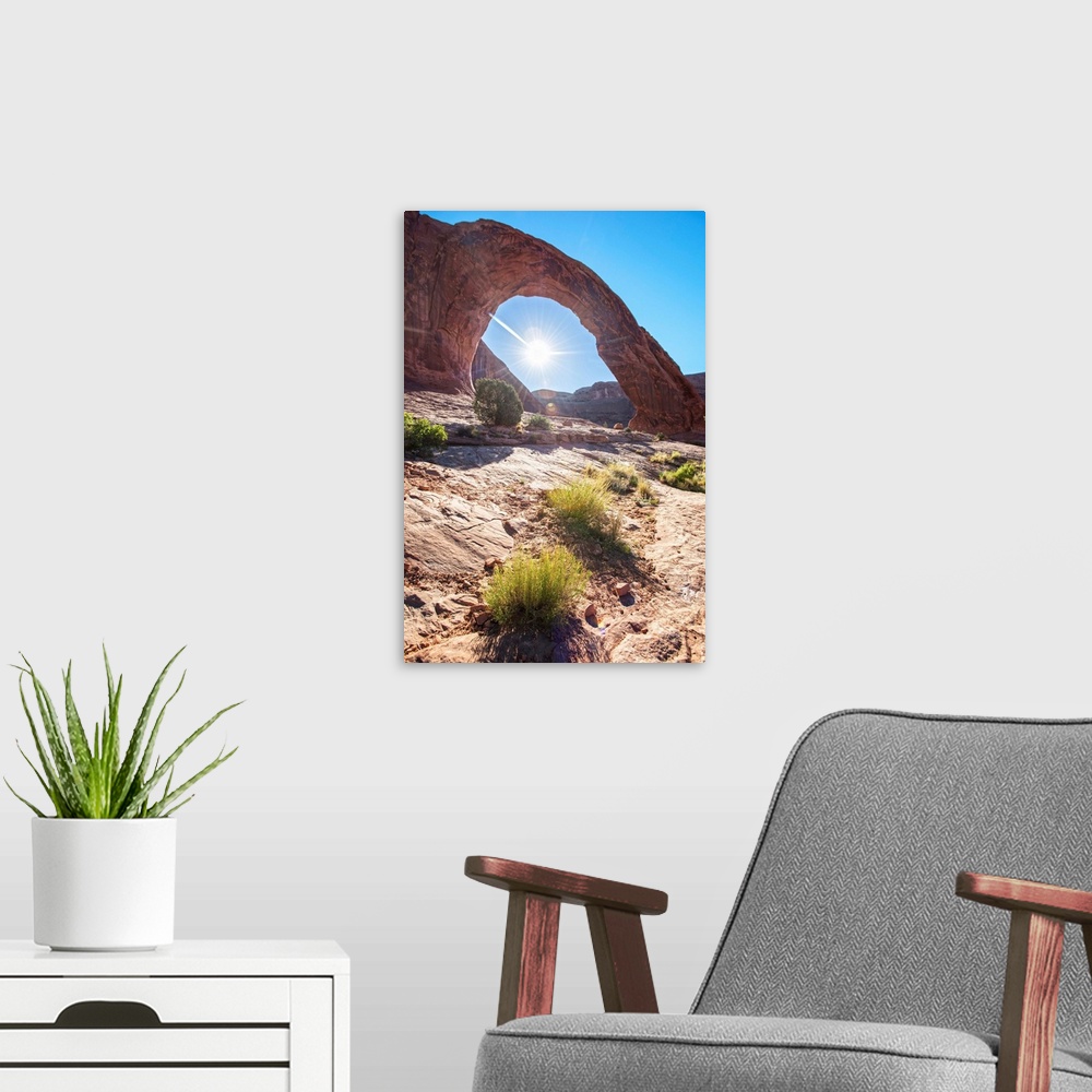 A modern room featuring The sun framed by the Corona Arch under a blue sky in Arches National Park, Utah.
