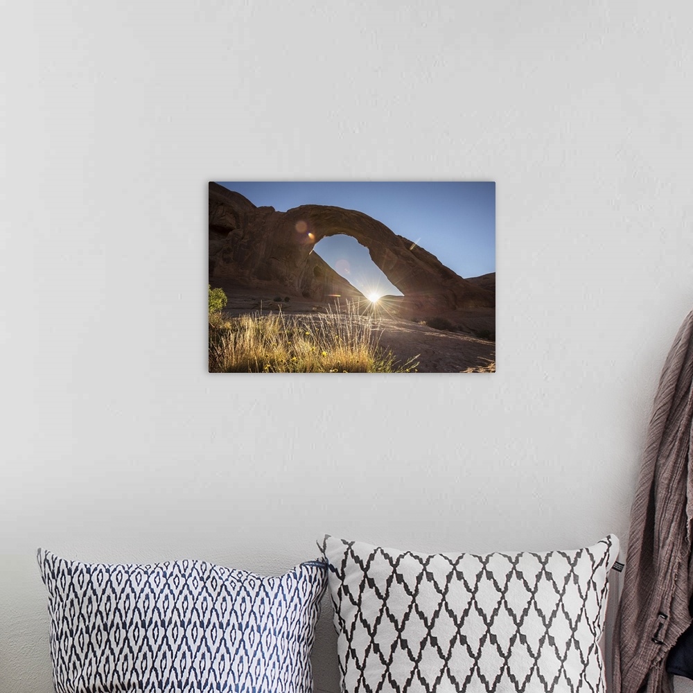 A bohemian room featuring The sun peeking behind the Corona Arch illuminating the desert grasses in Arches National Park, U...