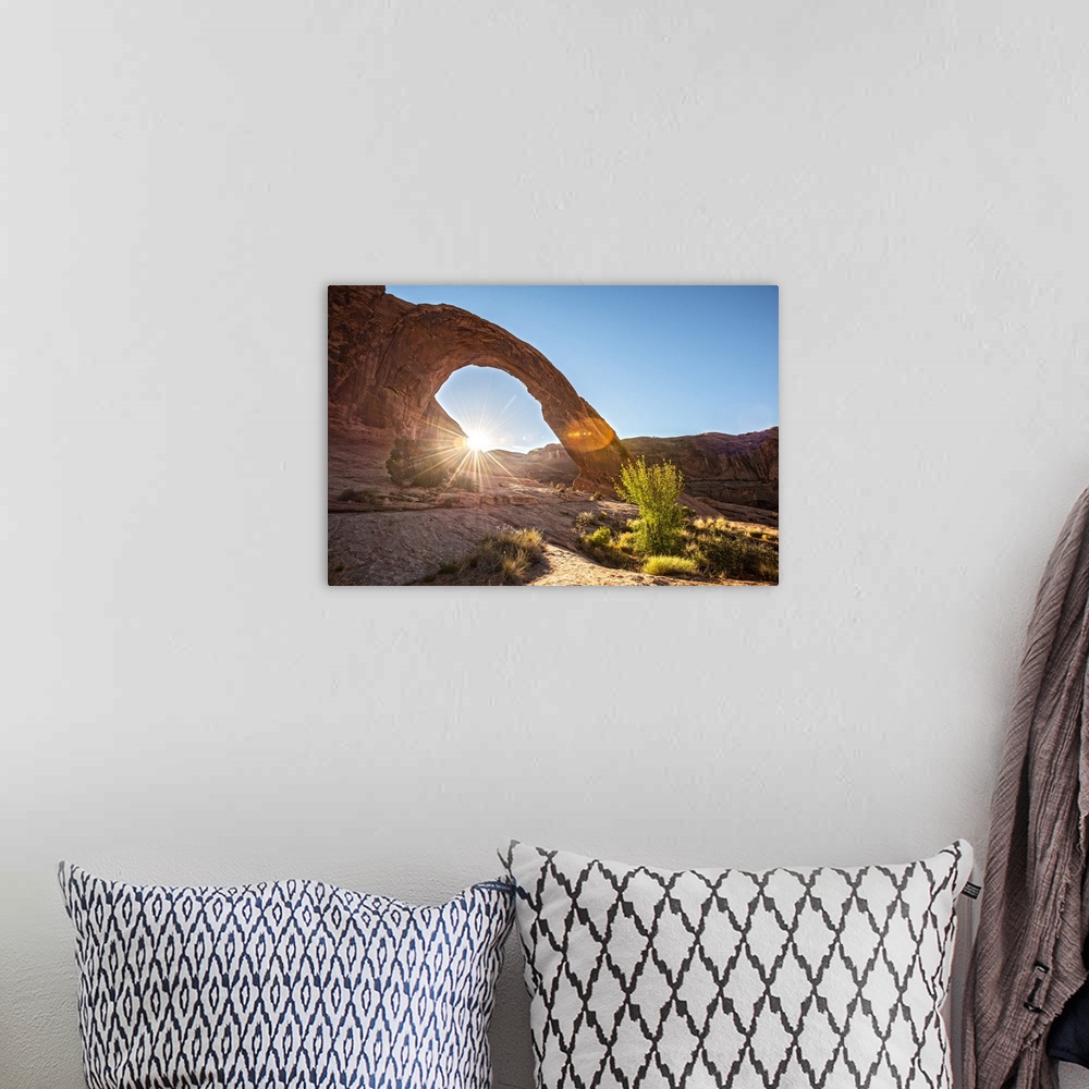 A bohemian room featuring The sun peeking behind the Corona Arch illuminating the desert grasses in Arches National Park, U...