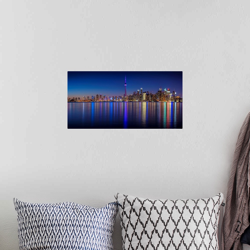 A bohemian room featuring Photo of the Toronto city skyline with lights reflected in the water at night.
