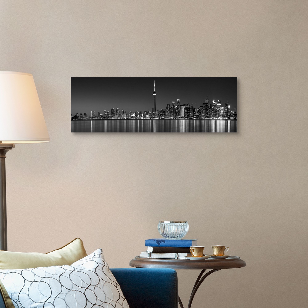 A traditional room featuring Panoramic photo of the Toronto city skyline with lights reflected in the water at night.