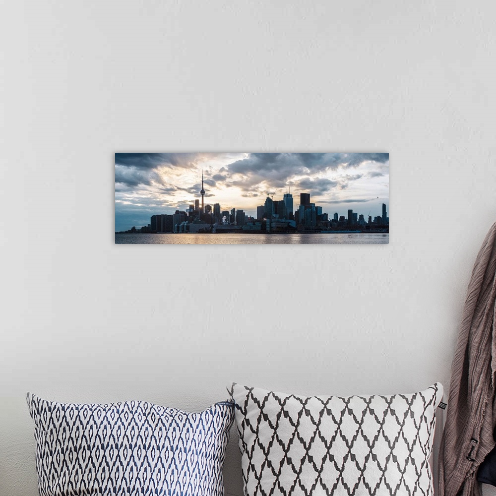 A bohemian room featuring Toronto city skyline under a dramatic sunset with clouds overhead, Ontario, Canada.
