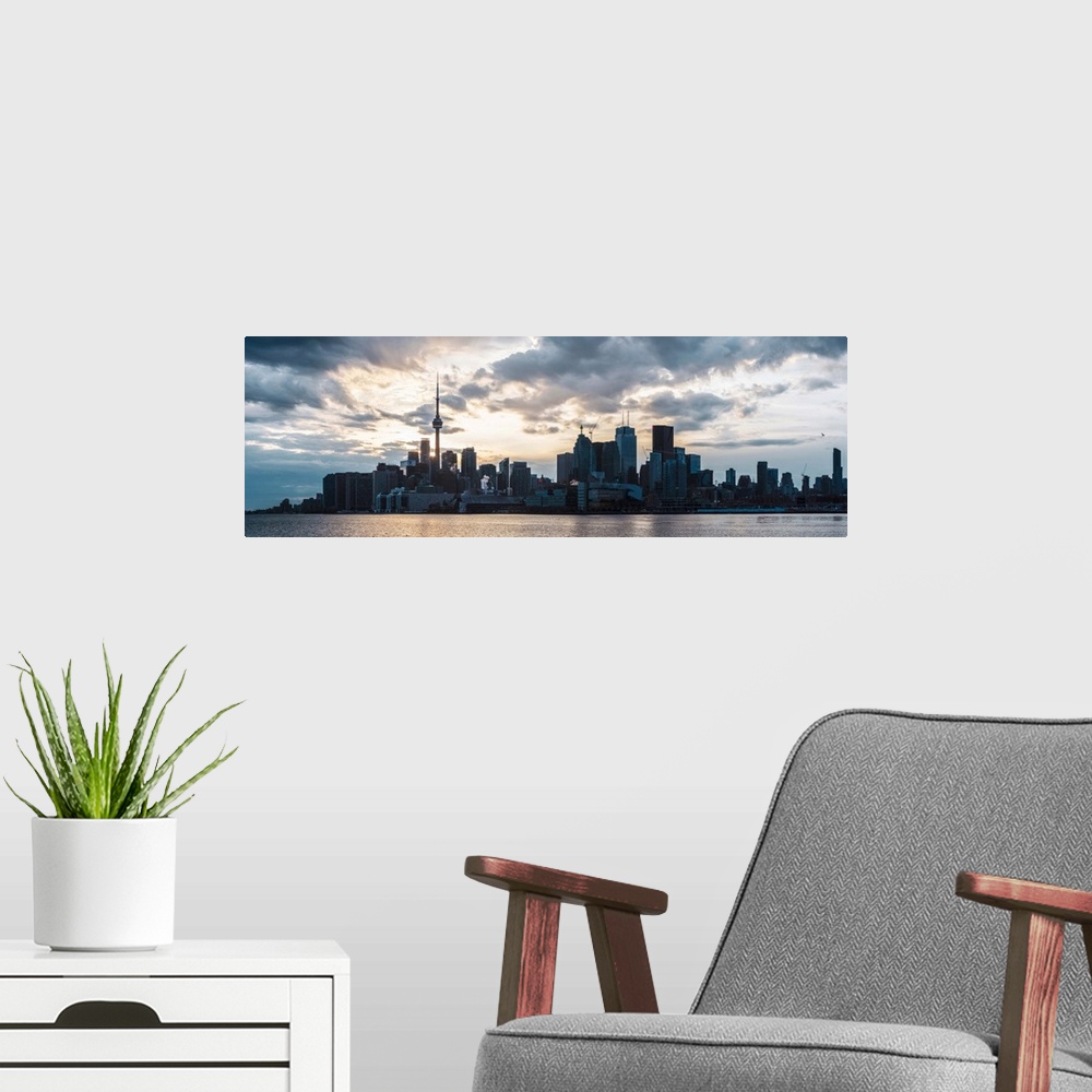 A modern room featuring Toronto city skyline under a dramatic sunset with clouds overhead, Ontario, Canada.
