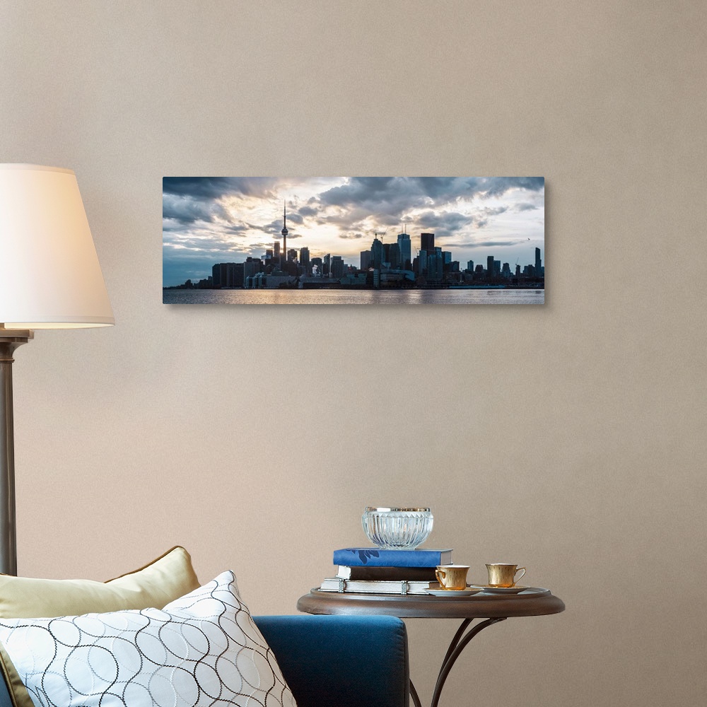 A traditional room featuring Toronto city skyline under a dramatic sunset with clouds overhead, Ontario, Canada.