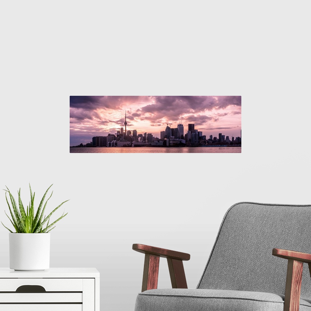 A modern room featuring Toronto city skyline under a dramatic sunset with clouds overhead, Ontario, Canada.