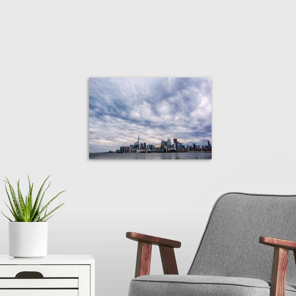 A modern room featuring Toronto city skyline under dramatic clouds, Ontario, Canada.
