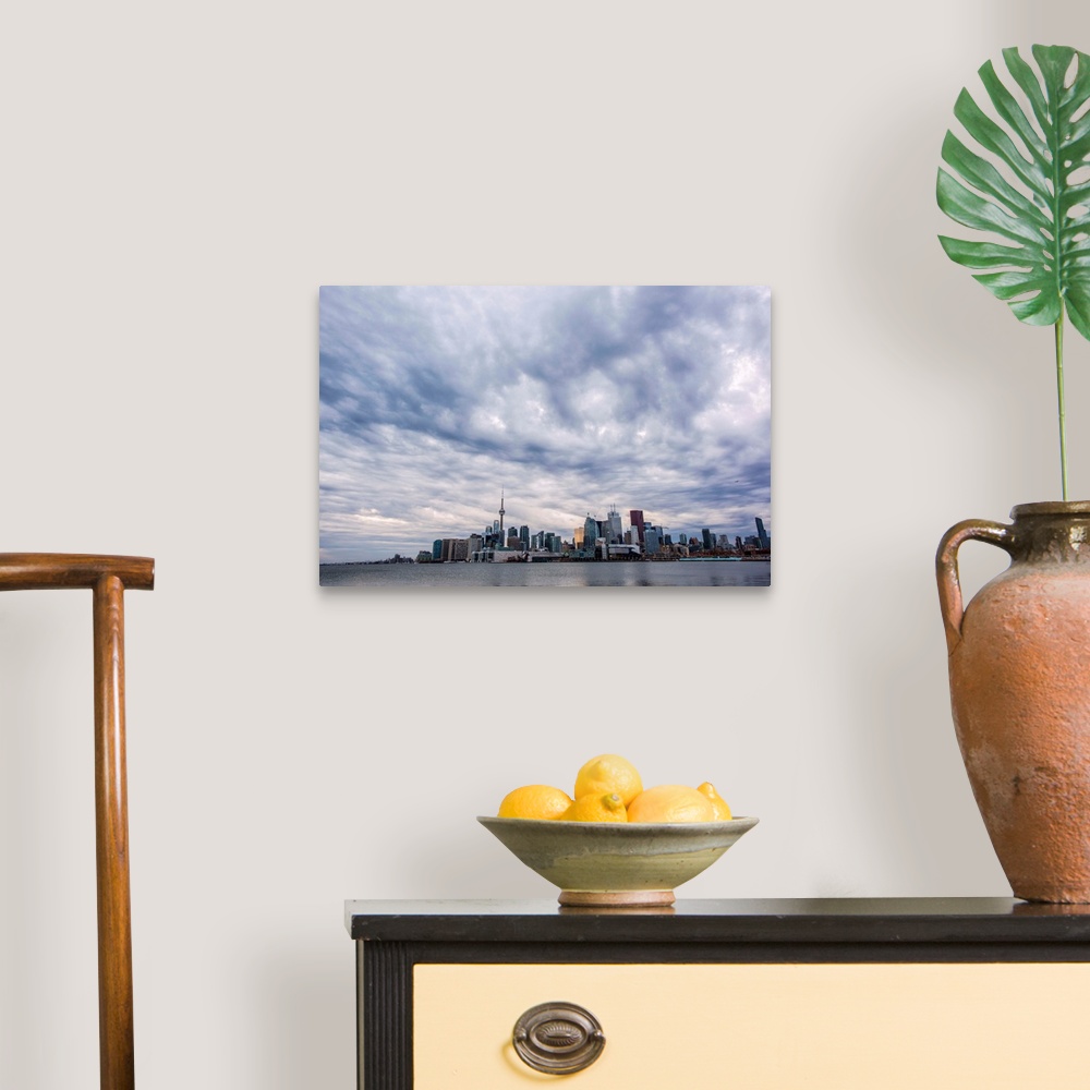 A traditional room featuring Toronto city skyline under dramatic clouds, Ontario, Canada.