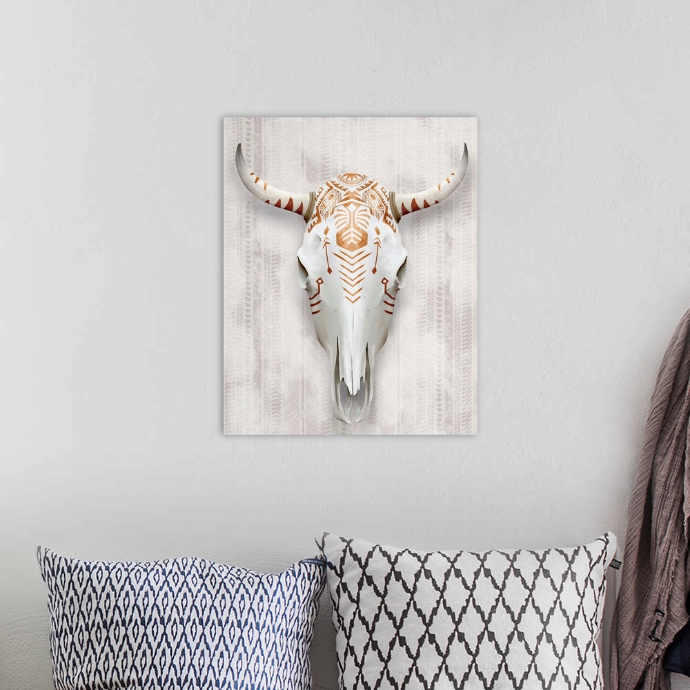 A bohemian room featuring A white bull's skull painted with copper-colored tribal patterns and symbols.