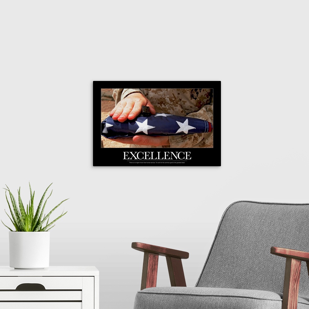 A modern room featuring Only the hands of a solider are photographed as they hold a folded flag with the word Excellence ...