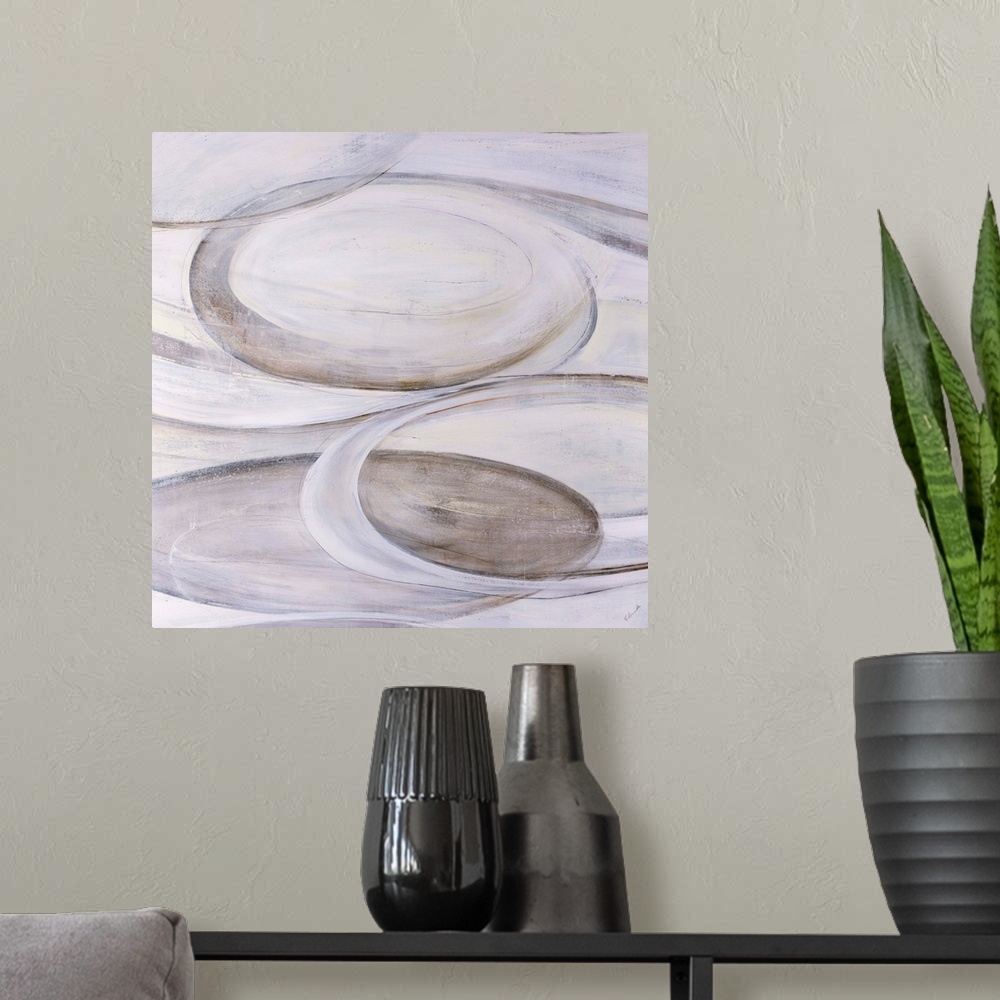 A modern room featuring Monochromatic abstract art of ovular shapes in various shades of cream.