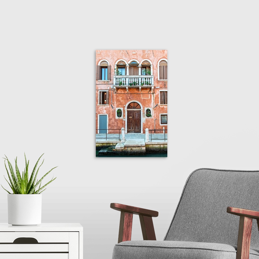 A modern room featuring Photograph of a salmon colored facade in Venice with a door, windows, and a balcony.