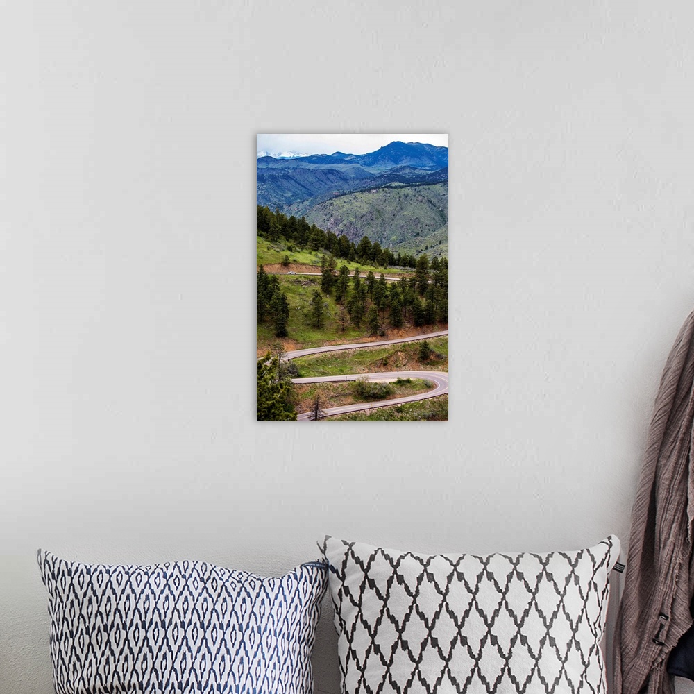 A bohemian room featuring Photo of a winding road below a mountain in Colorado.
