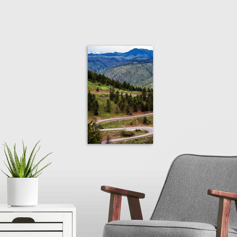 A modern room featuring Photo of a winding road below a mountain in Colorado.