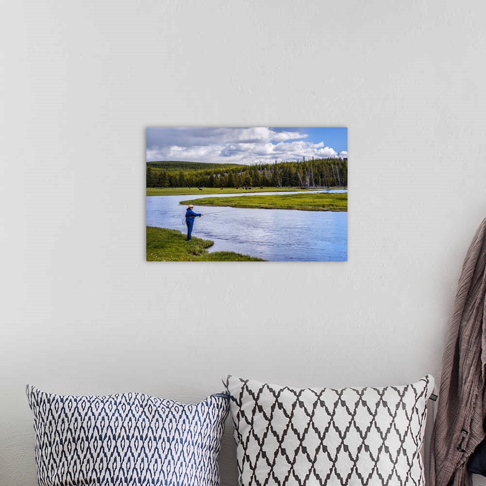 A bohemian room featuring Person fishing along a river at Yellowstone National Park.