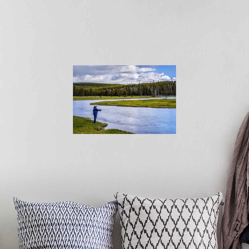 A bohemian room featuring Person fishing along a river at Yellowstone National Park.