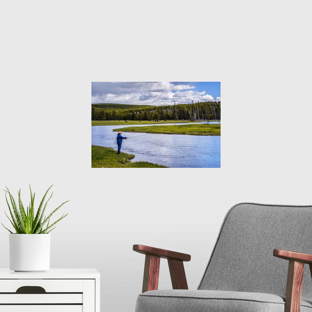 A modern room featuring Person fishing along a river at Yellowstone National Park.