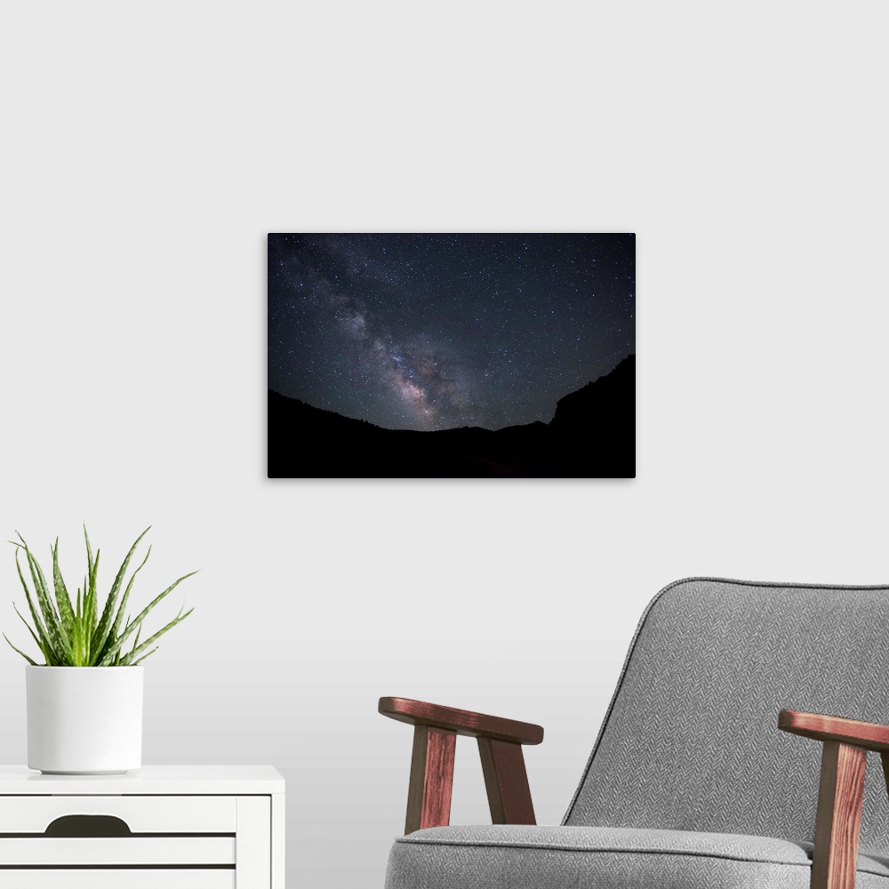 A modern room featuring Silhouette photograph of Zion National Park at night time with a starry sky and the Milky Way above.