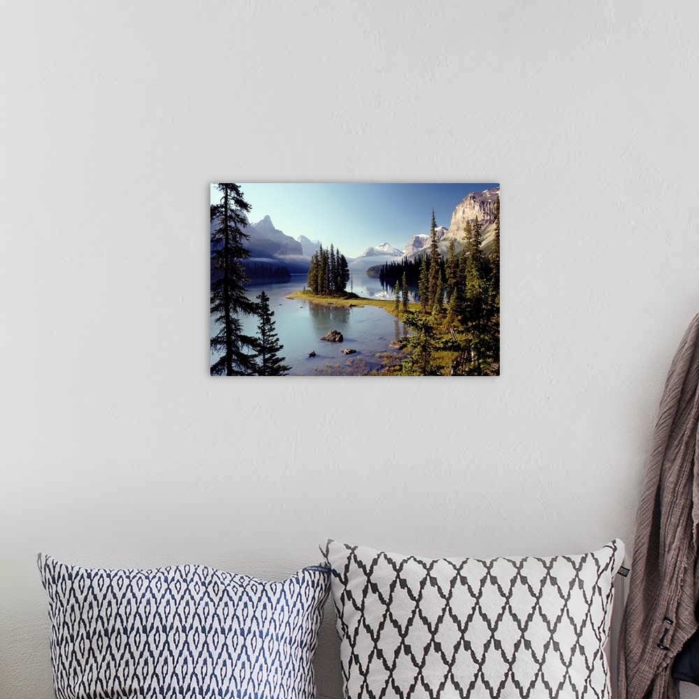 A bohemian room featuring Large wall print of a forest of evergreens meeting and jutting out into a clear lake surrounded b...