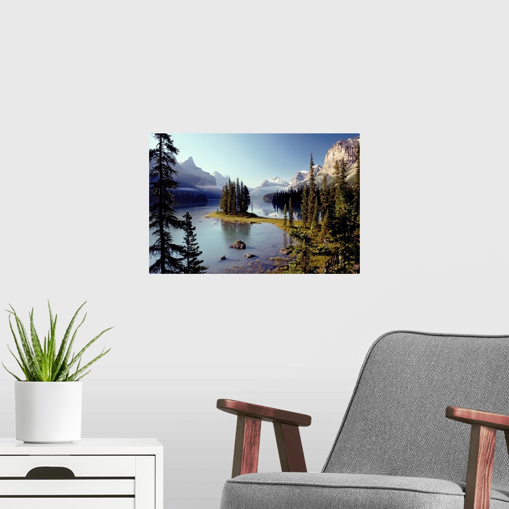 A modern room featuring Large wall print of a forest of evergreens meeting and jutting out into a clear lake surrounded b...