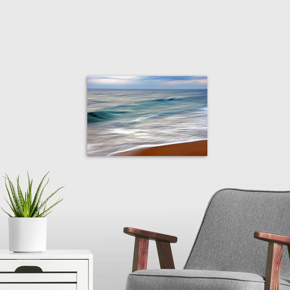 A modern room featuring Giant horizontal photograph from the National Geographic Collection of small blue waves reaching ...