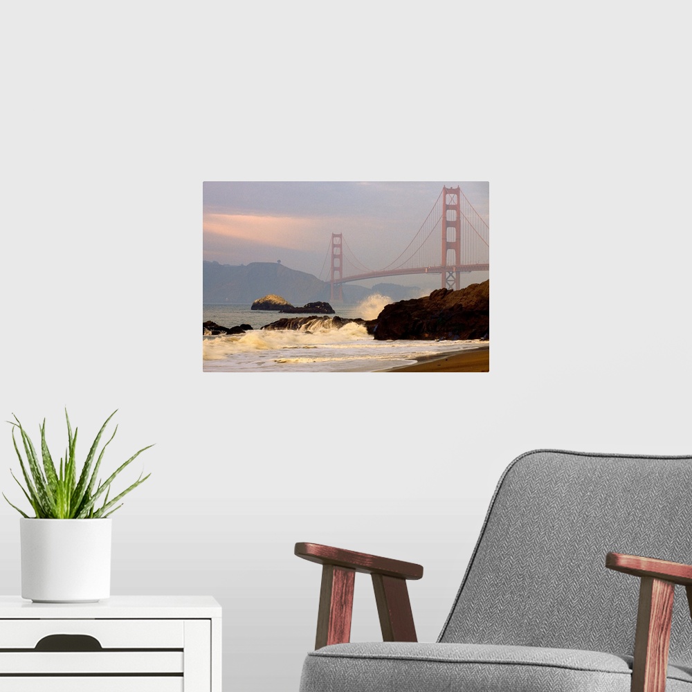 A modern room featuring From the National Geographic Collection a landscape photograph of waves crashing on a rocky shore...