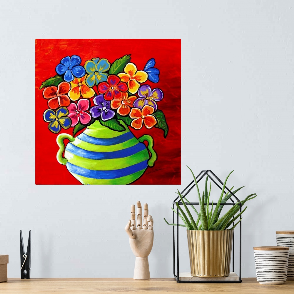 A bohemian room featuring Colorful blue and green striped vase filled with pansies of various colors.