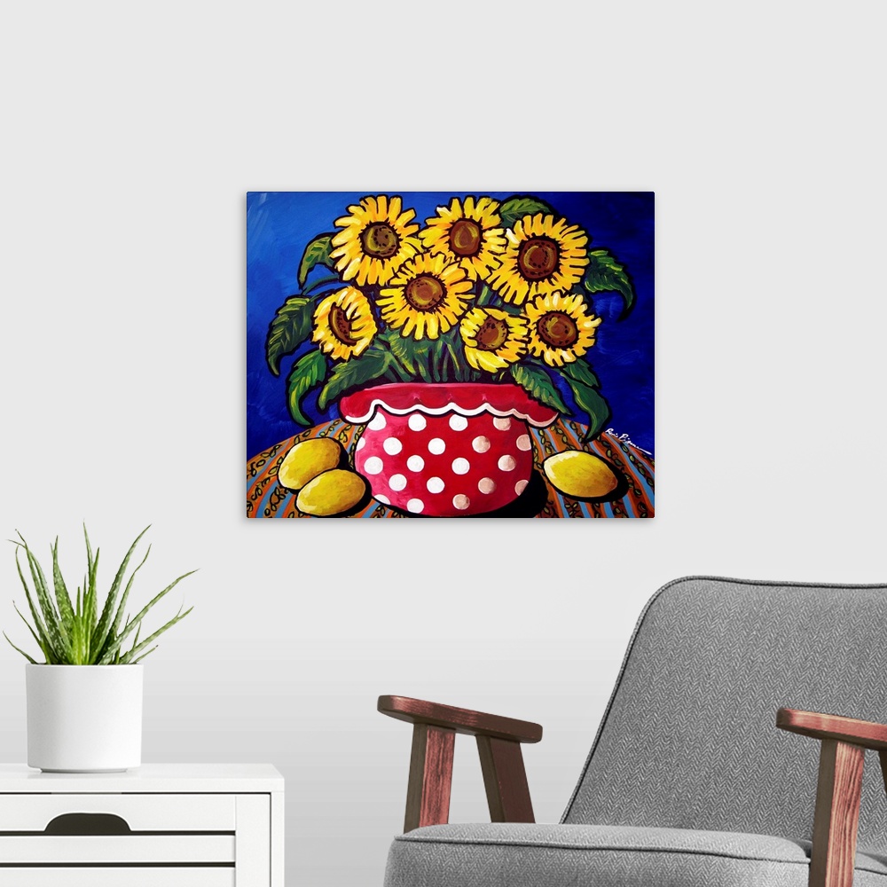 A modern room featuring Fun and colorful red polka dotted vase filled with sunflowers. Three lemons sit along side.