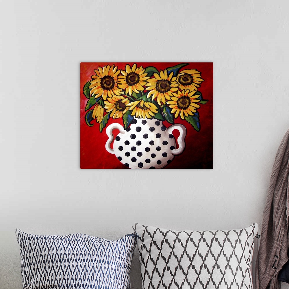 A bohemian room featuring Whimsical flavor with brightly colored sunflowers in a black and white vase.