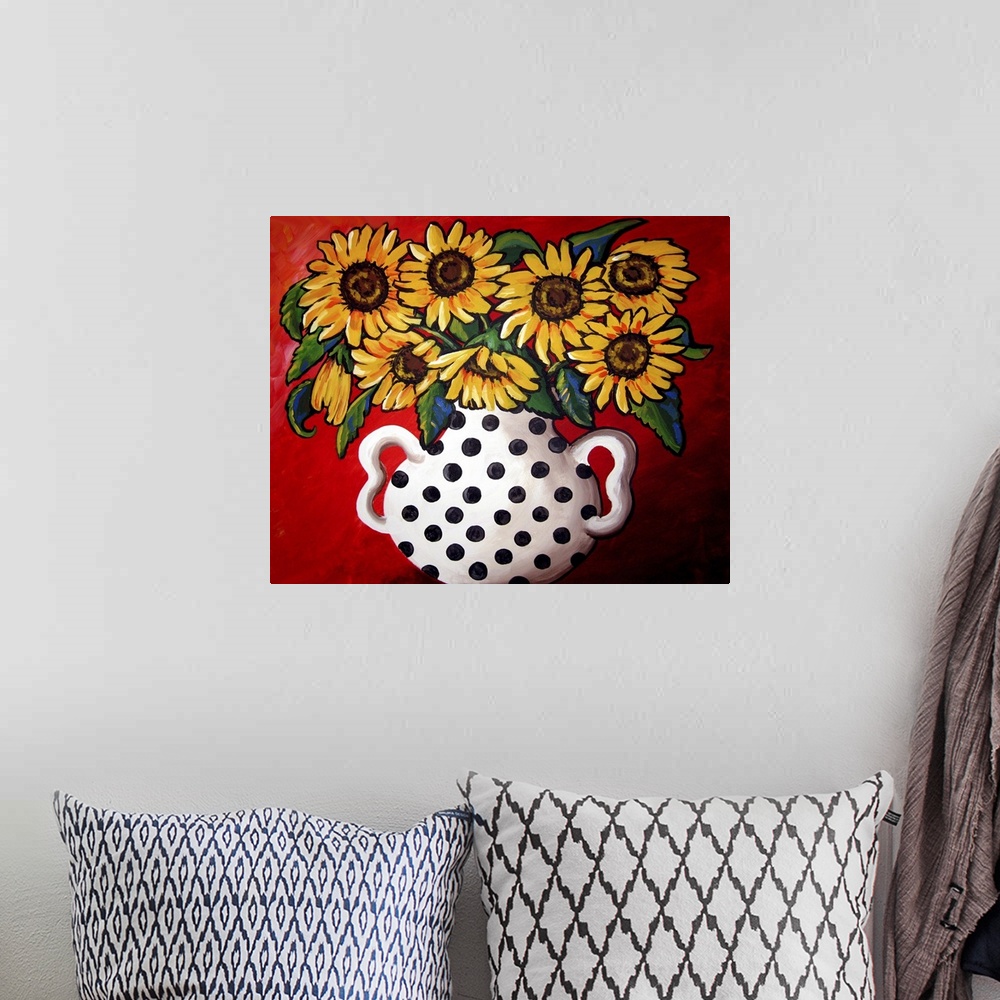 A bohemian room featuring Whimsical flavor with brightly colored sunflowers in a black and white vase.