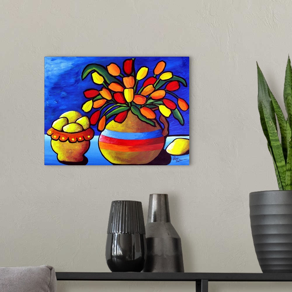 A modern room featuring Brightly colored tulips in a vase sit beside a bowl of lemons, against deep blue background