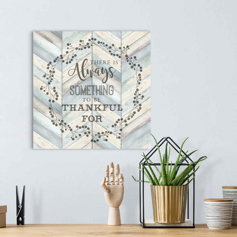 A bohemian room featuring "There Is Always Something To Be Thankful For" surround by a wreath on a chevron wood background.