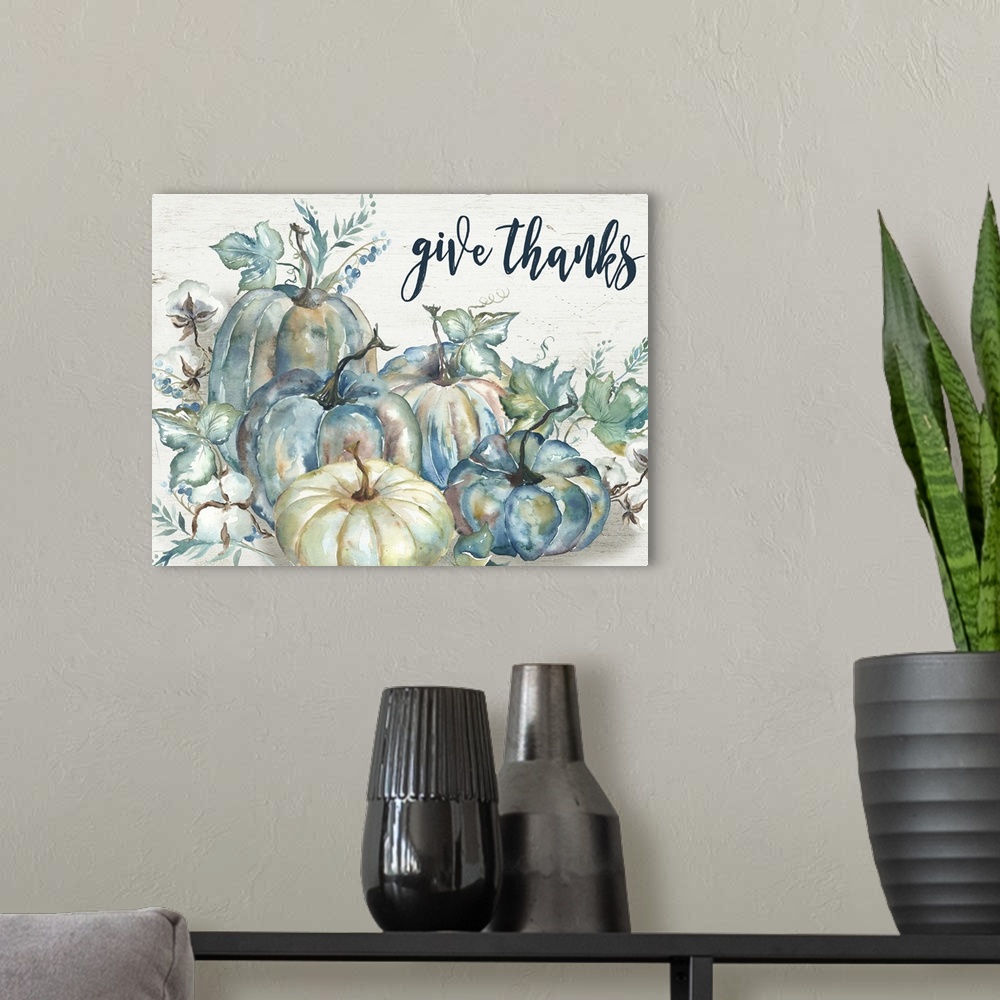A modern room featuring "Give Thanks" on a watercolor painting of a group of pumpkins with autumn leaves.