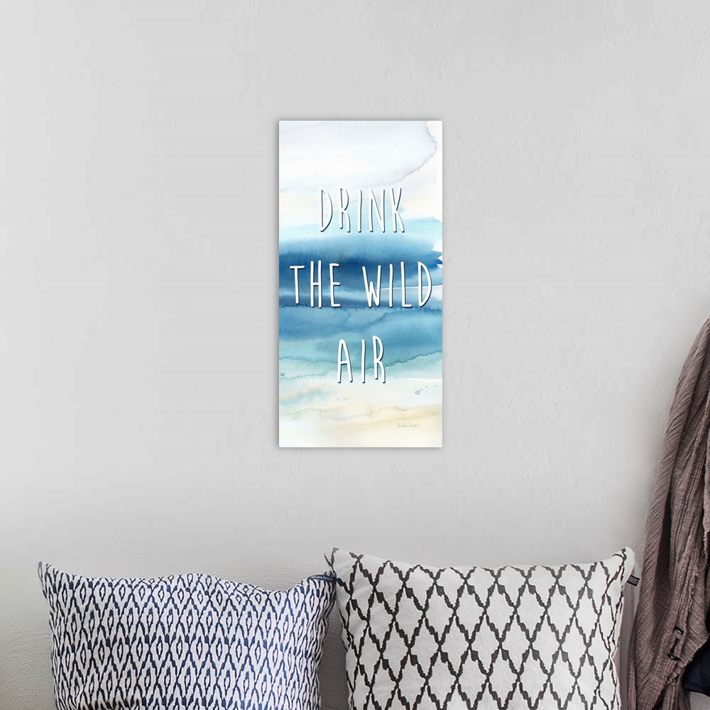 A bohemian room featuring "Drink The Wild Air" in white on a watercolor painting of the ocean.