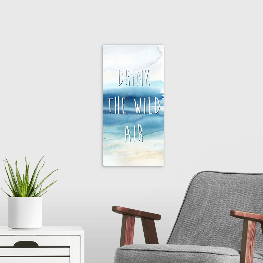 A modern room featuring "Drink The Wild Air" in white on a watercolor painting of the ocean.