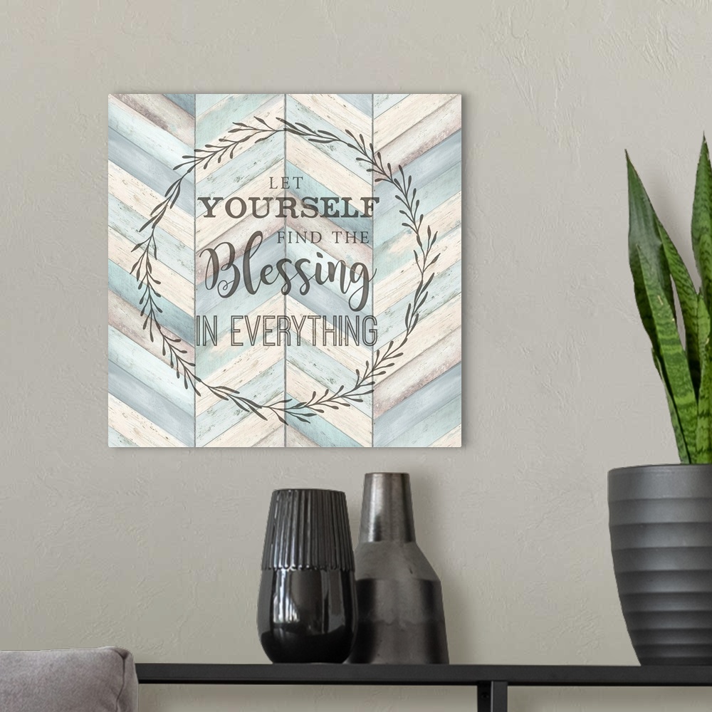 A modern room featuring "Let Yourself Find The Blessing In Everything" surround by a wreath on a chevron wood background.