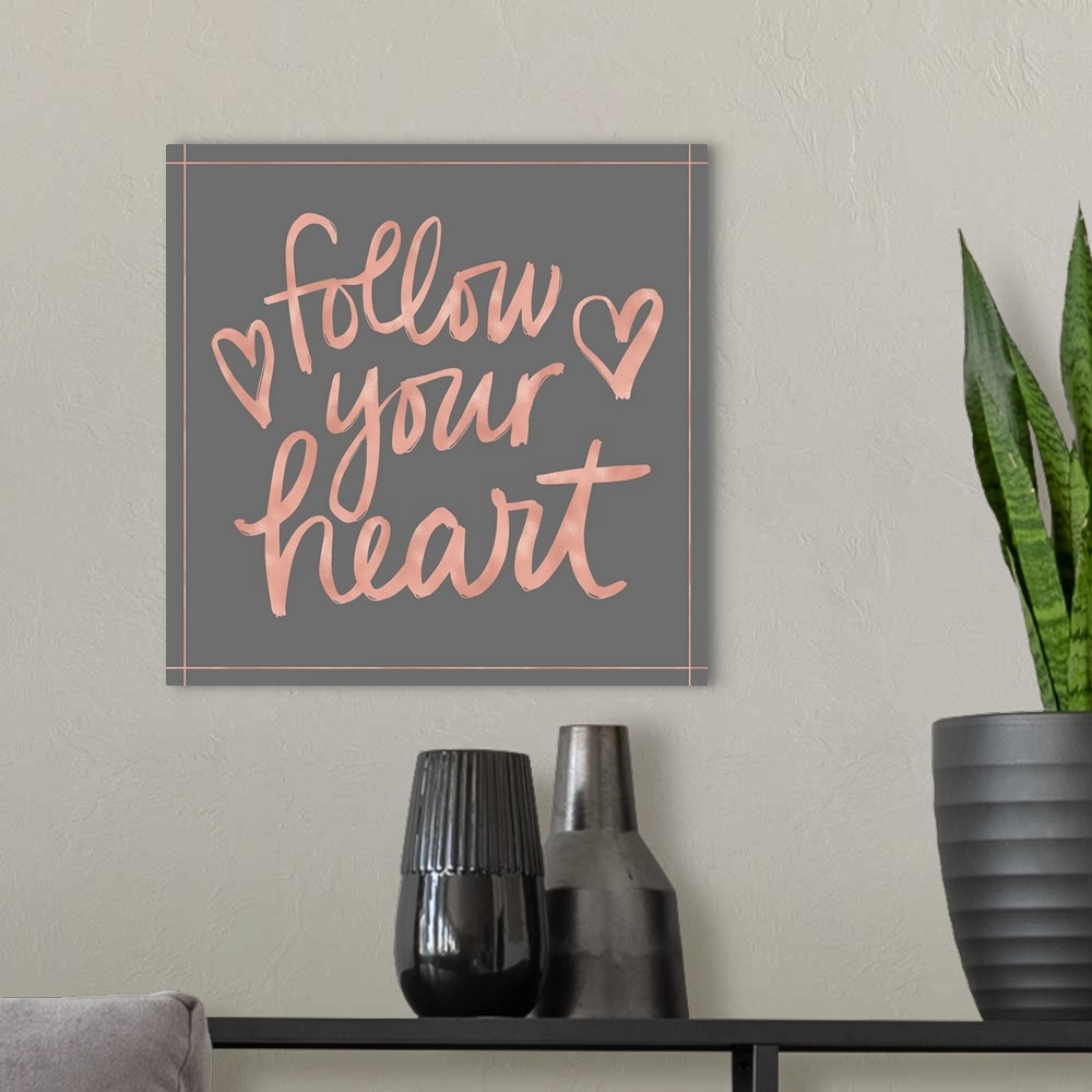 A modern room featuring "Follow your heart" in pink with a heart on a gray background.