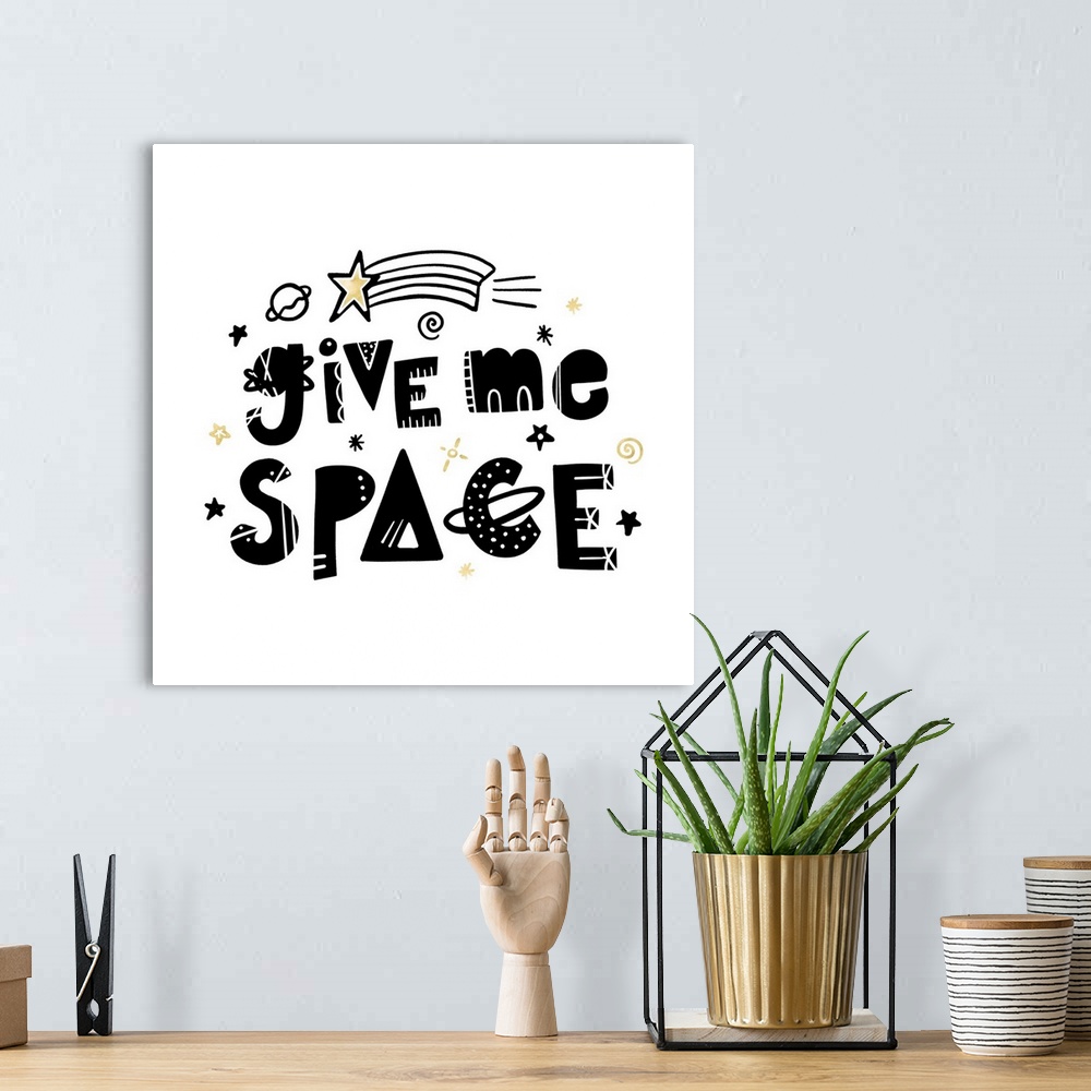 A bohemian room featuring "Give Me Space" in an artistic font with stars and planets on a white background and gold accents.