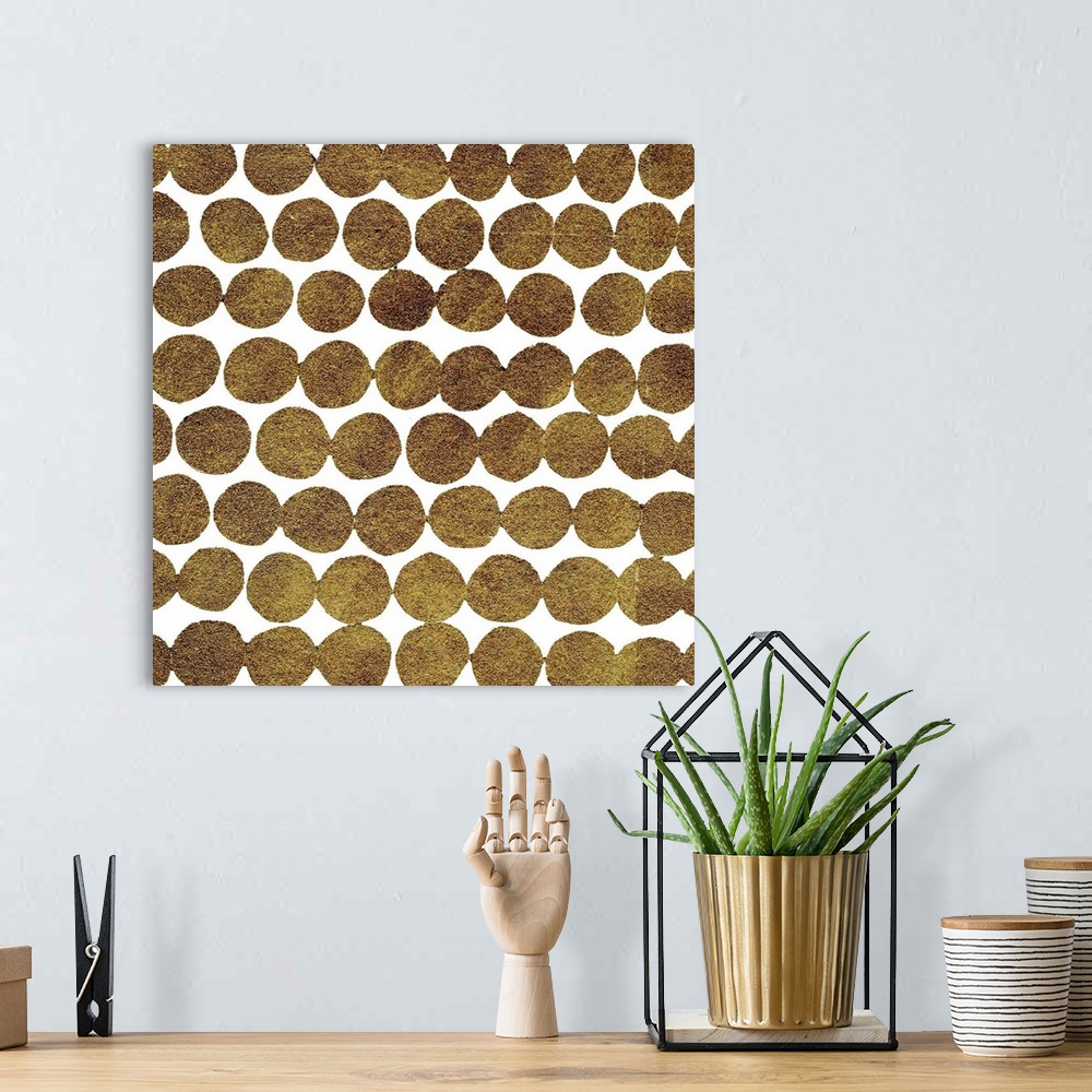 A bohemian room featuring Square decorative artwork of dark gold circles in rows on a white background.