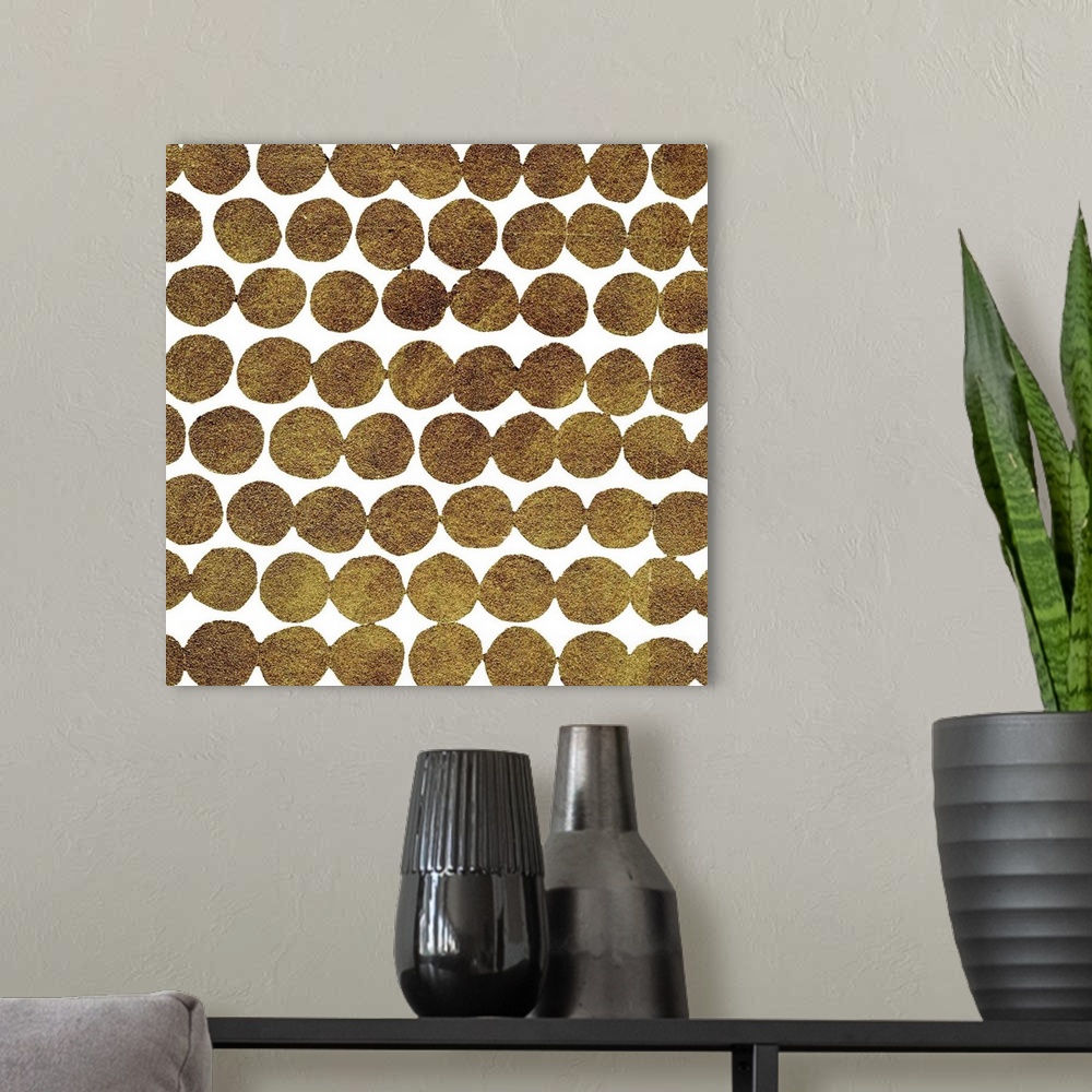 A modern room featuring Square decorative artwork of dark gold circles in rows on a white background.