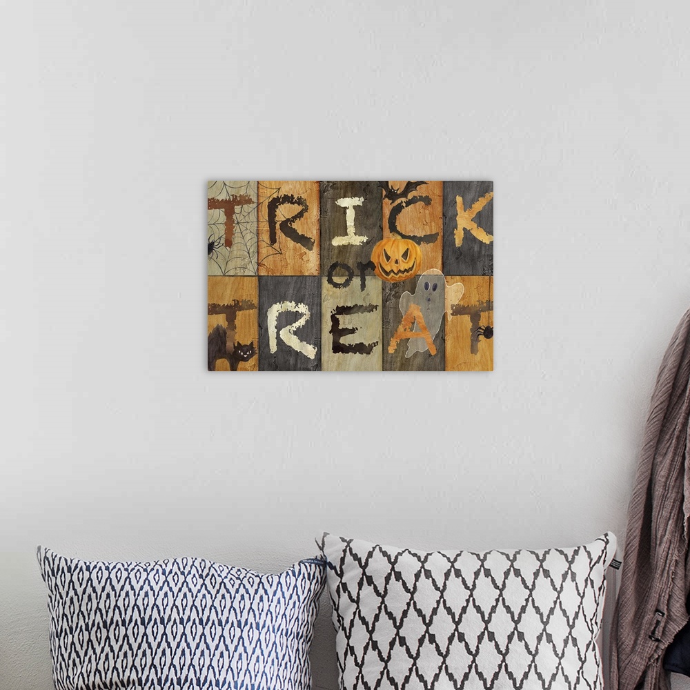A bohemian room featuring A decorative Halloween design of spooky objects like a ghost, bat and spider with the text "Trick...