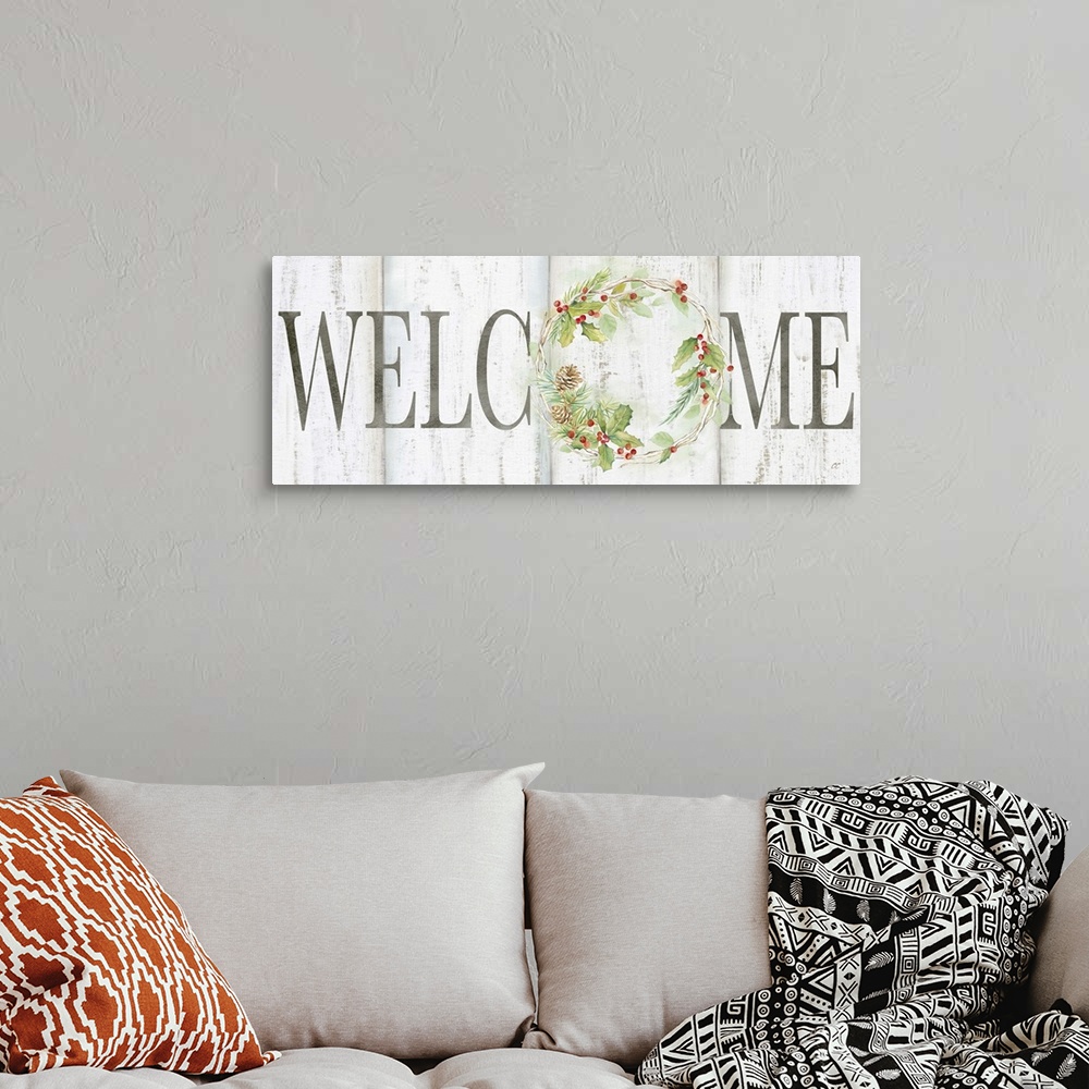 A bohemian room featuring "Welcome" with a holiday wreath of pine and holly on a white wood background.
