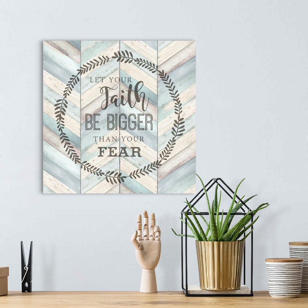 A bohemian room featuring "Let your faith Be Bigger Than Your Fear" surround by a wreath on a chevron wood background.