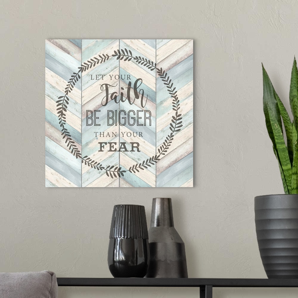 A modern room featuring "Let your faith Be Bigger Than Your Fear" surround by a wreath on a chevron wood background.