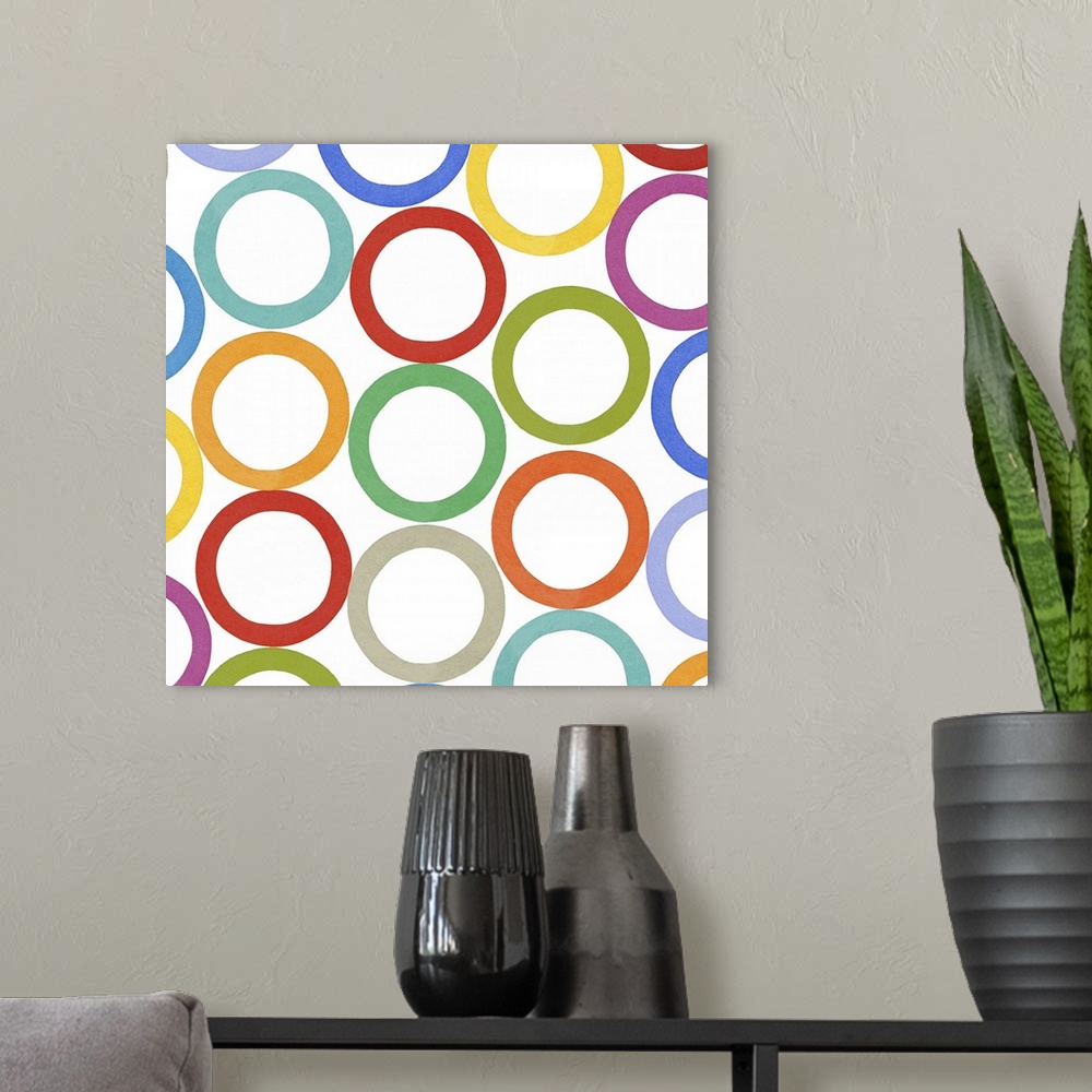 A modern room featuring Square decorative artwork of multi-colored circles in rows on a white background.